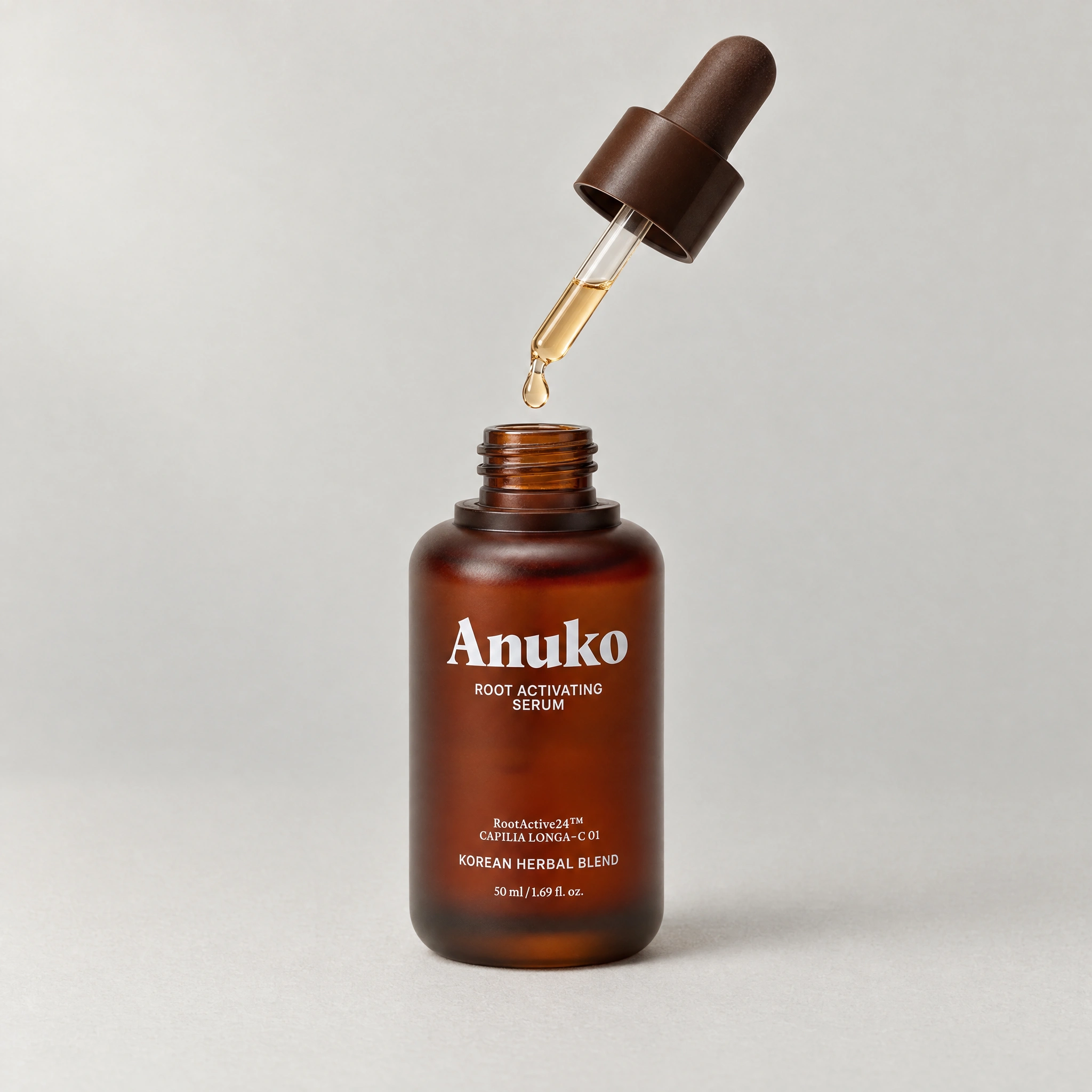 The Anuko Root Activating Serum dropper releasing a drop above the open bottle