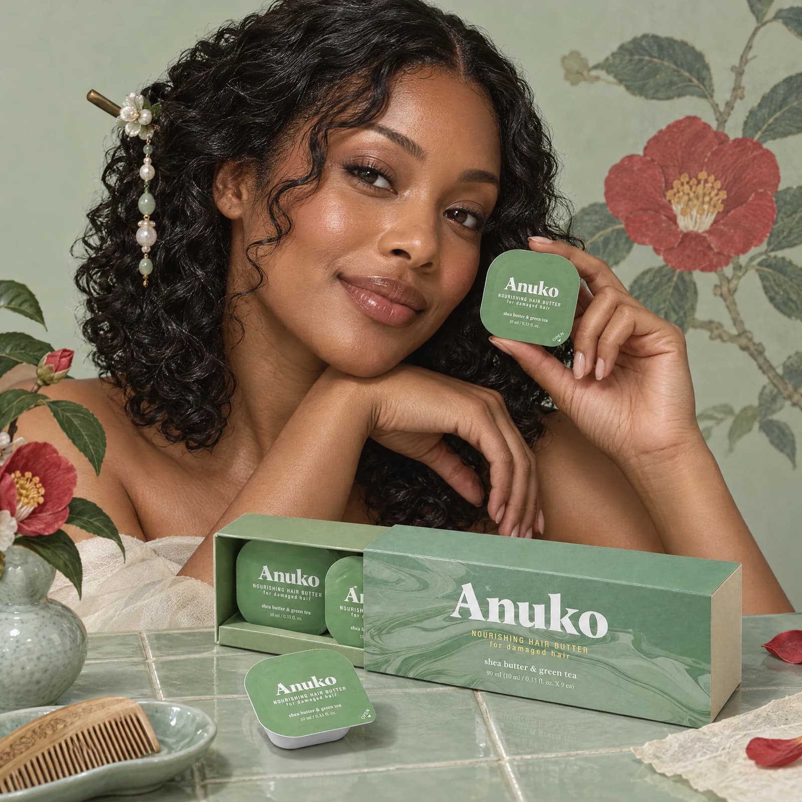 Model with curls holding a Travel Hair Butter capsule
